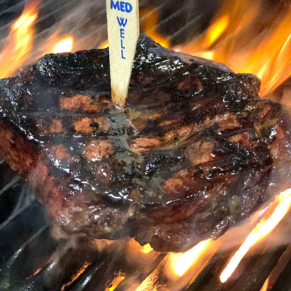 A steak cooking over the open char grill at Outback Jacks Northbridge